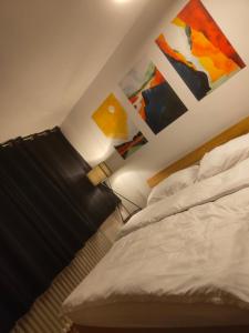 1 dormitorio con 1 cama con lámpara y pinturas en la pared en Gästezimmer nahe Therme Bad Wörishofen, en Bad Wörishofen