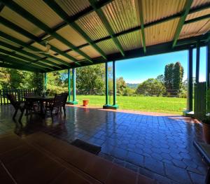 een grote afgeschermde veranda met een tafel en stoelen bij Irish Hills - two bedroom apartment in Hilton