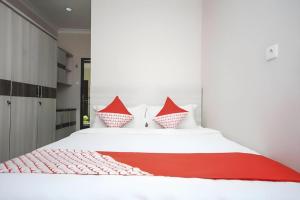 a bedroom with a white bed with red pillows at Super OYO 270 Madinah Residence Syariah in Talang Kelapa +30 photos