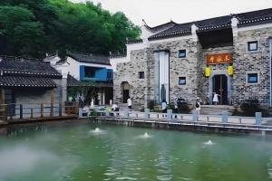 ein Gebäude mit einem Teich davor in der Unterkunft GreenTree Inn Huangshi Huahu Development Zone Daquan Road in Huangshigang