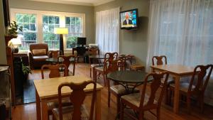 a living room with tables and chairs and a television at The University Inn at Emory in Atlanta