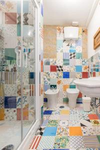 Un baño con suelo de mosaico y lavabo e inodoro. en Magma Home - Rooms & Roof, en Nápoles 58 fotos más