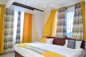 - une chambre avec 2 lits et des fenêtres avec des rideaux dans l'établissement MTWAPA LUXURY Posta, à Mombasa