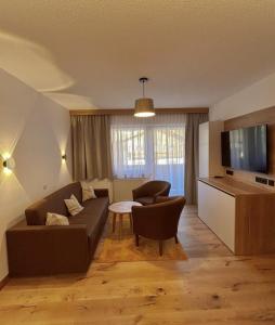 una sala de estar con un sofá y una mesa en Appartement Christian, en Maurach