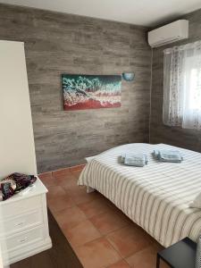 una camera da letto con un letto e un quadro sul muro di Villa Cristipaulo a Praia de Faro