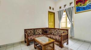 Hotel O My Guest House Syariah في Kepuh: غرفة معيشة بها أريكة وطاولة