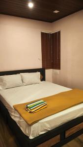 a bed with a towel on top of it at Cloud Peak in Vagamon