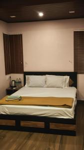 a bedroom with a large bed with white sheets and pillows at Cloud Peak in Vagamon +4 photos