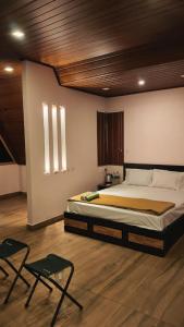 a bedroom with a large bed and two chairs at Cloud Peak in Vagamon
