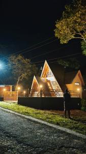 a man walking in front of a house at night at Cloud Peak in Vagamon