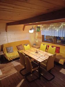 a dining room with a table and chairs and a bed at Chata Safran in Donovaly