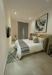 Un dormitorio con una cama grande y un televisor. en The Estoria Lagos, en Ikeja