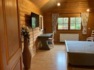 ein Zimmer mit einem Tisch und einem Schreibtisch in einem Holzzimmer in der Unterkunft Landhaus An der Schafgasse in Spittelstein