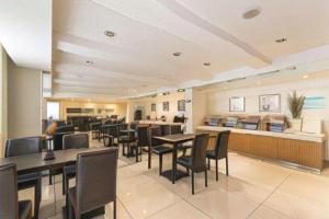 uma sala de jantar com mesas e cadeiras em um prédio em Jinjiang Inn Select Qingdao West Coast Coach Exhibition Center High-Speed Railway Station em Huangdao