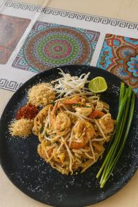 a plate of food with shrimp and noodles on a table at Moonshine Phayam beach resort & restaurant in Ranong