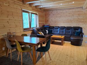 a living room with a leather couch and a table at Chatô Liptov in Liptovský Mikuláš