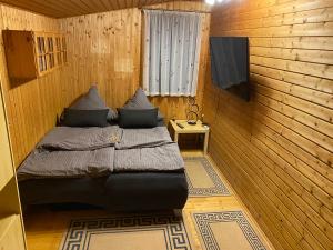 a bedroom with a bed in a wooden room at Waldidyll in Plötzky