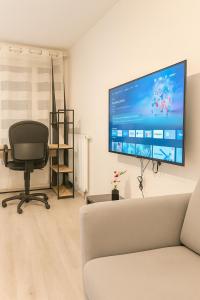 a living room with a chair and a large screen tv at Ducastel F2 Appartment in Juvisy-sur-Orge +4 photos
