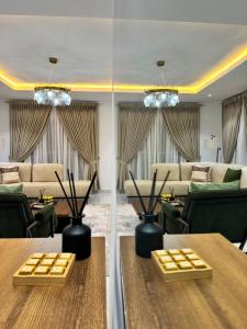 a living room with tables and couches and chairs at Amik Homes in Aso