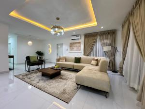 a living room with a couch and a table at Amik Homes in Aso