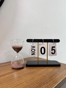 a glass of wine sitting next to a clock with the wordoser at Amik Homes in Aso +2 photos