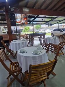 two tables and chairs with white table cloths on them at 2204 Chácara Pousada CadClub Quarto Suíte Para Casal in Sao Jose do Rio Preto