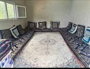 een woonkamer met een groot tapijt op de vloer bij Maksyt Ata Hostel in Kalday