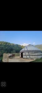 een groot gebouw met een koepel, een tafel en stoelen bij Maksyt Ata Hostel in Kalday