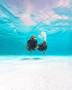 a man floating in the water in the ocean at Nala Maldives by Jawakara in Lhaviyani Atoll