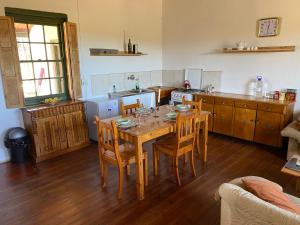 een keuken met een houten tafel met stoelen en een eetkamer bij Infinity farm in Riversdale