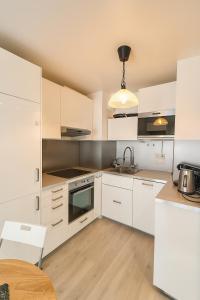 a white kitchen with white cabinets and a table at Ducastel F2 Appartment in Juvisy-sur-Orge