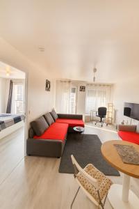 a living room with a red couch and a bed at Ducastel F2 Appartment in Juvisy-sur-Orge