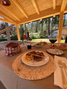 a table with a plate of food and a bottle of wine at I Larici Camping Lodge in Ossana