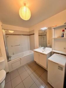 a bathroom with a toilet and a tub and a sink at Ducastel F2 Appartment in Juvisy-sur-Orge