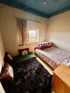 a small room with two beds and a window at La Belle Etoile in Ouazzane