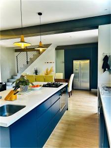 een keuken met blauwe kasten en een woonkamer bij KommRust in Kommetjie