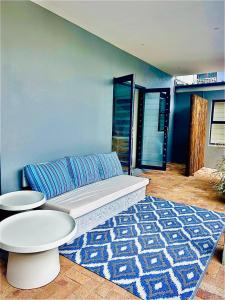 een woonkamer met een bank en een blauwe muur bij KommRust in Kommetjie