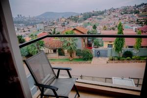 einen Balkon mit einem Stuhl und Stadtblick in der Unterkunft Agasaro House Kigali in Kigali