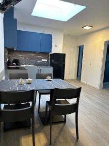 Hotel A24 bei Hamburg في غلينده: مطبخ مع طاولة وكراسي ودواليب زرقاء