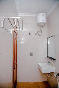 ein Badezimmer mit Waschbecken und Spiegel in der Unterkunft Agasaro House Kigali in Kigali