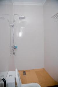 ein weißes Badezimmer mit Dusche und Toilette in der Unterkunft Agasaro House Kigali in Kigali + 32 Fotos