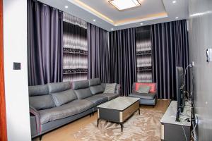 ein Wohnzimmer mit Sofa und Tisch in der Unterkunft Agasaro House Kigali in Kigali