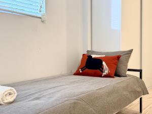 ein Schlafzimmer mit einem Bett mit einem roten Kissen darauf in der Unterkunft Private Granny Flat Studio in Chatswood in Sydney + 1 Foto