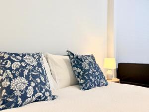 ein Bett mit blauen und weißen Kissen darauf in der Unterkunft Private Granny Flat Studio in Chatswood in Sydney