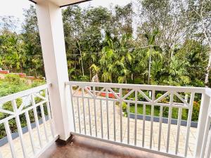 un balcón con una valla blanca y árboles en tanis homestay, en Jāmb 17 fotos más