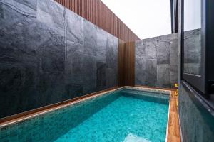 a bathroom with a swimming pool in a room at Tonnam pool villa in Nong Prue +10 photos