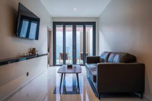 a living room with a couch and a table at Tonnam pool villa in Nong Prue