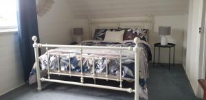 a bedroom with a bed with a white frame at Kipsie Cottage - Point Lonsdale in Point Lonsdale