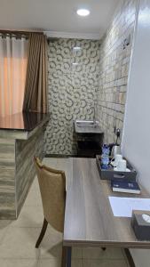 cocina con fregadero y mesa con silla en Nokras SilverOak Hotel, Embu, en Embu