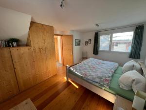 a bedroom with a bed and a window at Chesa Tre Piz in Maloja +1 photo